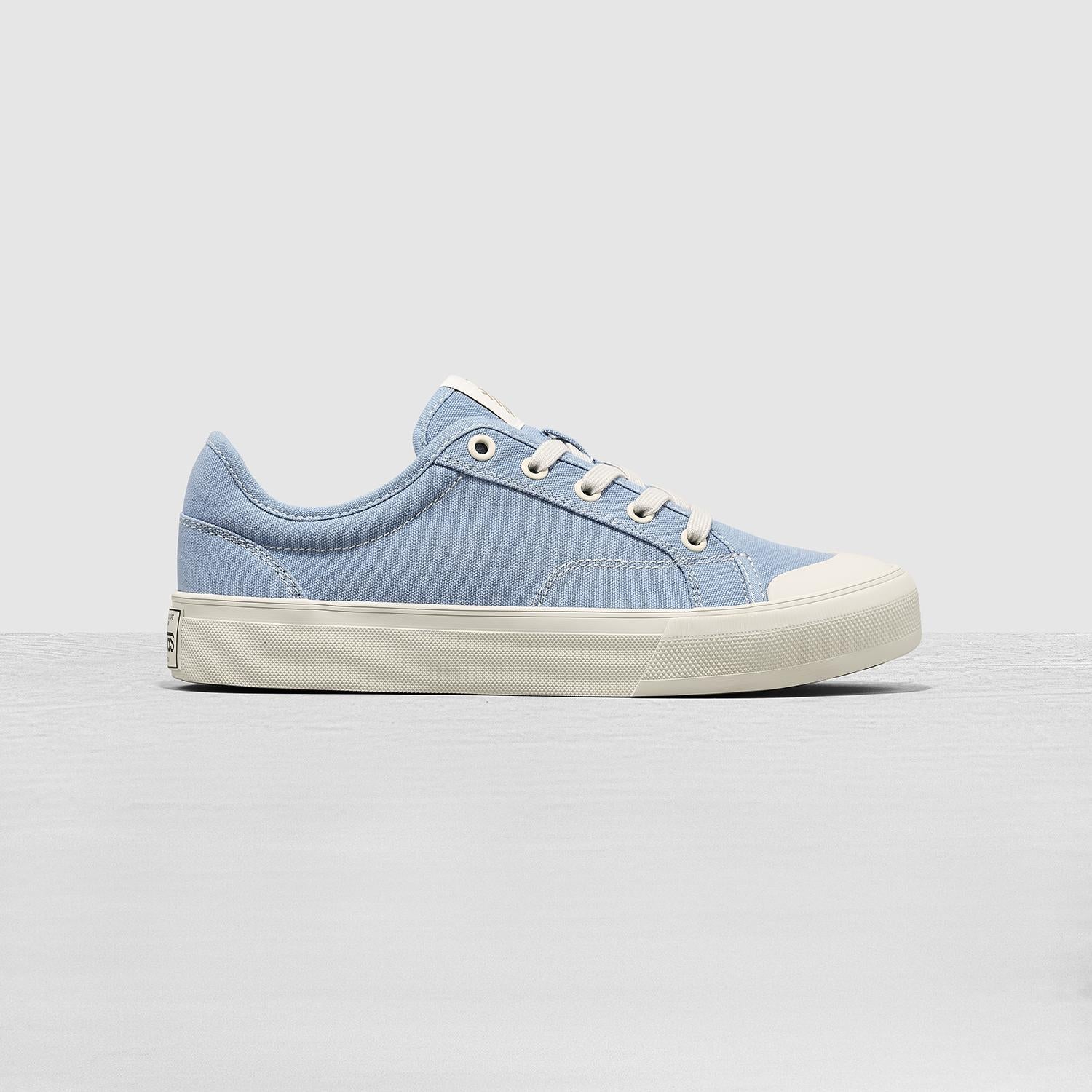 Light blue sneaker with white sole on a light gray background